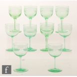 A collection of uranium green wine glasses comprising a set of four with round funnel bowls with a