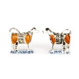 A mirrored pair of early 19th Century creamware cow creamers and covers each with a seated milkmaid