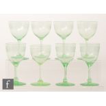 A collection of uranium green wine glasses with round funnel bowls,