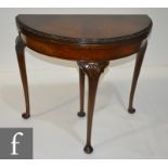 A 1920s walnut demi-lune card table with carved detail moulded edge on shell carved cabriole legs