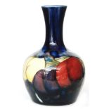 A small William Moorcroft vase of globe and shaft form decorated in the Wisteria pattern on blue,