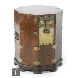A 20th Century Chinese oak octagonal twin handled box or chest, with brass mounts on shaped feet,