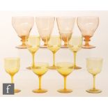 A collection of golden amber stemware, including a pair of wine glasses with ovoid bowls,