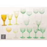 A collection of assorted uranium glass stemware, mainly green but some golden amber examples,