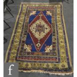 A Caucasian rug with central floral lozenge on a blue ground within an interspaced floral border,