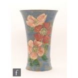 A 1930s Royal Doulton Wild Roses flared vase decorated with painted roses against a mottled blue