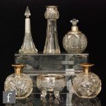 Four hallmarked silver and clear glass dressing table bottles and vases to include a thistle shaped