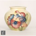 A small Moorcroft vase of ovoid form decorated in the Frilled Orchid pattern against a yellow to