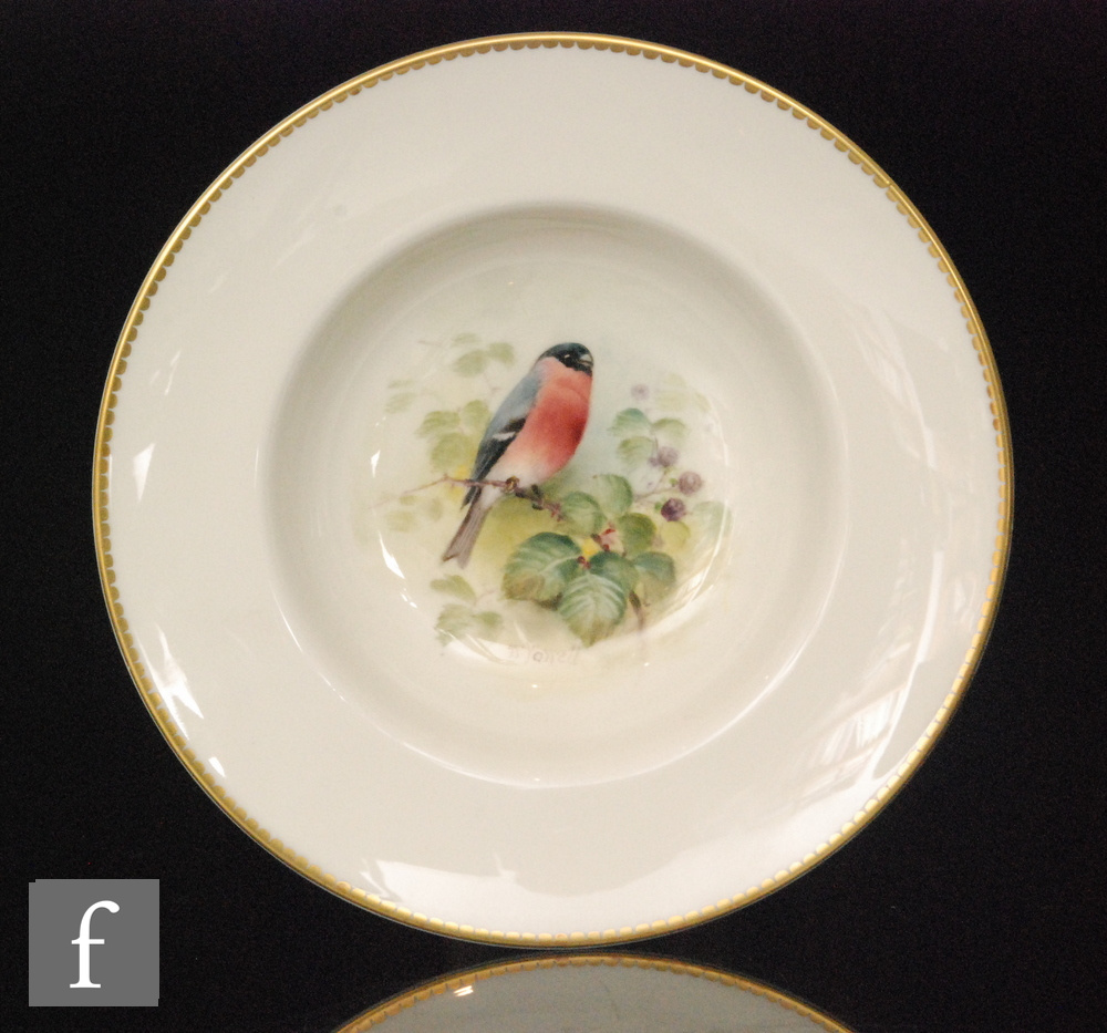 A Royal Worcester shallow bowl with a wide brim decorated to the central well with a hand painted