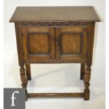 A small 17th Century style oak cupboard enclosed by a pair hatched diamond inlaid doors on turned