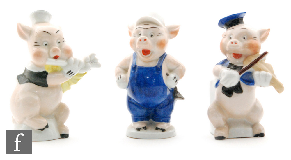 Three 1930s Walt Disney toothbrush holders modelled as the Three Little Pigs from the 1933 film,