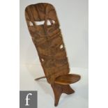 An African hardwood folding chair, the back carved in high relief and detailed with wild animals.