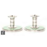 A pair of hallmarked silver candlesticks with plain columnar capital and green enamelled wide