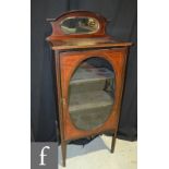 An edwardian line inlaid mahogany music cabinet, the interior enclosed by an oval glazed door,