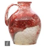 Ruskin Pottery - A high fired flower jug decorated in an all over sang de boeuf glaze with a