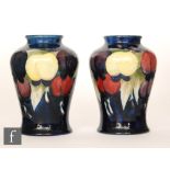 William Moorcroft - A pair of footed baluster form vases decorated in the Wisteria pattern,