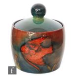 William Moorcroft - A cylindrical tobacco box and cover decorated in the Flambe Fish pattern with