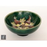 Moorcroft - A small footed bowl decorated in the Columbine pattern with a central tubelined flower