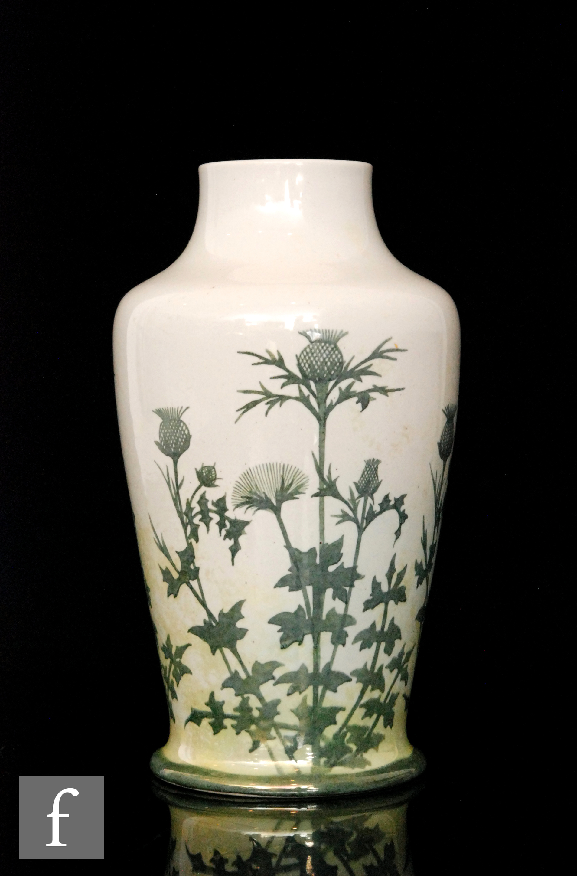 Ruskin Pottery - A vase of footed baluster form decorated in the round with hand painted thistle