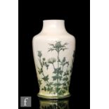 Ruskin Pottery - A vase of footed baluster form decorated in the round with hand painted thistle