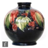 William Moorcroft - An ovoid vase decorated in the Leaf and Blackberry pattern against a blue wash