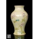 William Moorcroft - Liberty & Co - A baluster form vase decorated in the Lilac pattern,