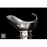 Charles Boyton - A hallmarked silver sauce boat oval base rising to ribbed flying scroll handle,