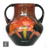 William Moorcroft - A large twin handled vase decorated in the Flambe Claremont pattern with three