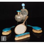 A hallmarked silver and blue gillouche enamel decoration backed brush set to include three brushes,