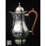 A hallmarked silver baluster coffee pot of plain from terminating in wooden scroll handle,