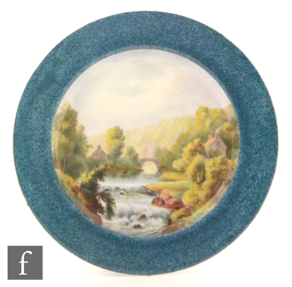 A Royal Worcester blue ground plate with central painted river landscape scene signed Flaxman,