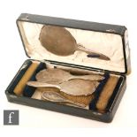 A cased hallmarked silver backed six piece brush set with engine turned decoration around engraved