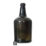 A large 18th Century olive green glass wine bottle of mallet form with applied lip, height 37cm.