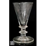 An early 19th Century goblet with a large conical bowl above a bladed knop with waisted stem and