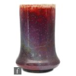 A Ruskin Pottery high fired Elephants Foot vase decorated in a red and lavender glaze with copper