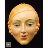 A 1930s moulded plaster wall mask of a female face with blue eyes and blonde hair, height 16cm, S/D.