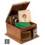 A 1920s oak cased table top gramophone retailed by Meads Balsall Heath Birmingham with needle tins