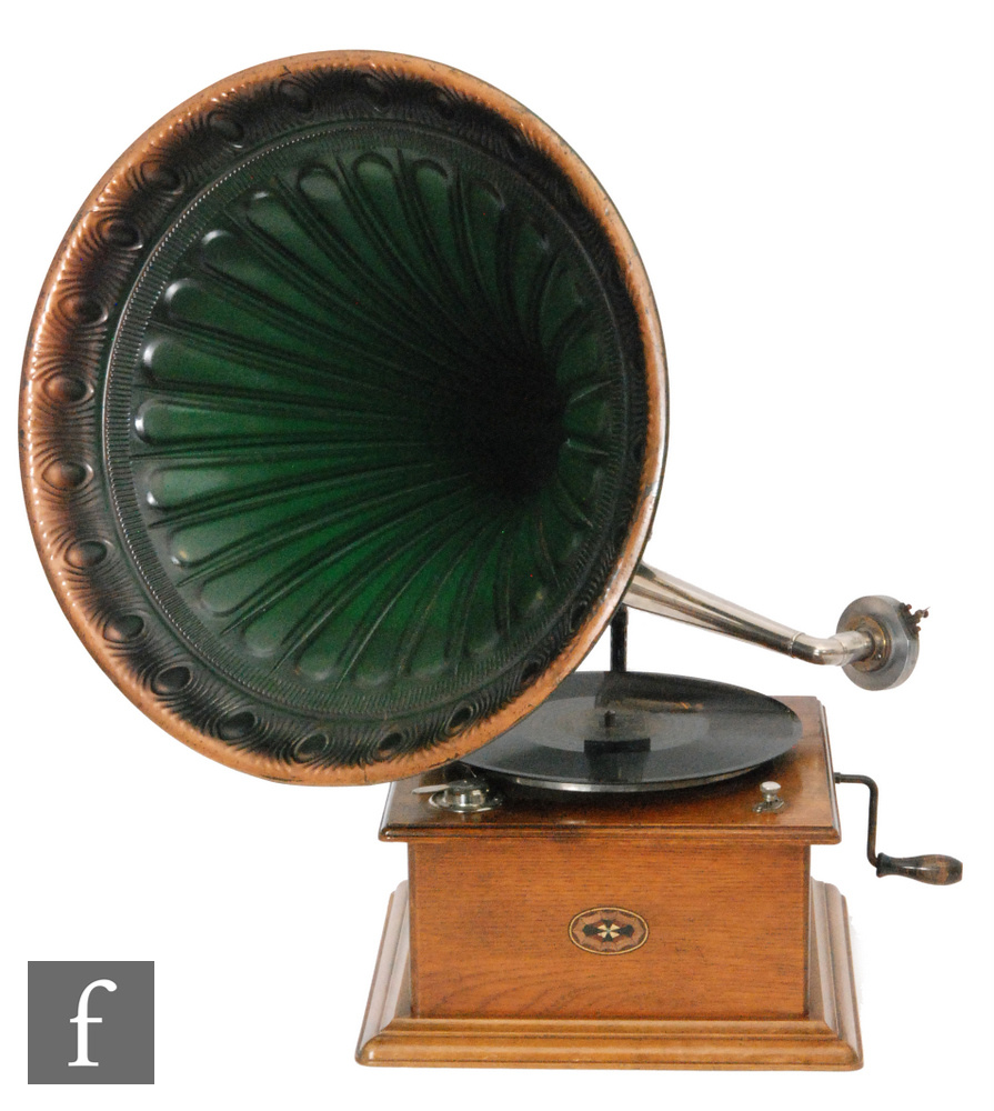 A 1920s Continental oak cased wind up gramophone with green tin horn on stepped plinth base,
