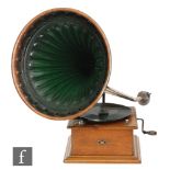 A 1920s Continental oak cased wind up gramophone with green tin horn on stepped plinth base,