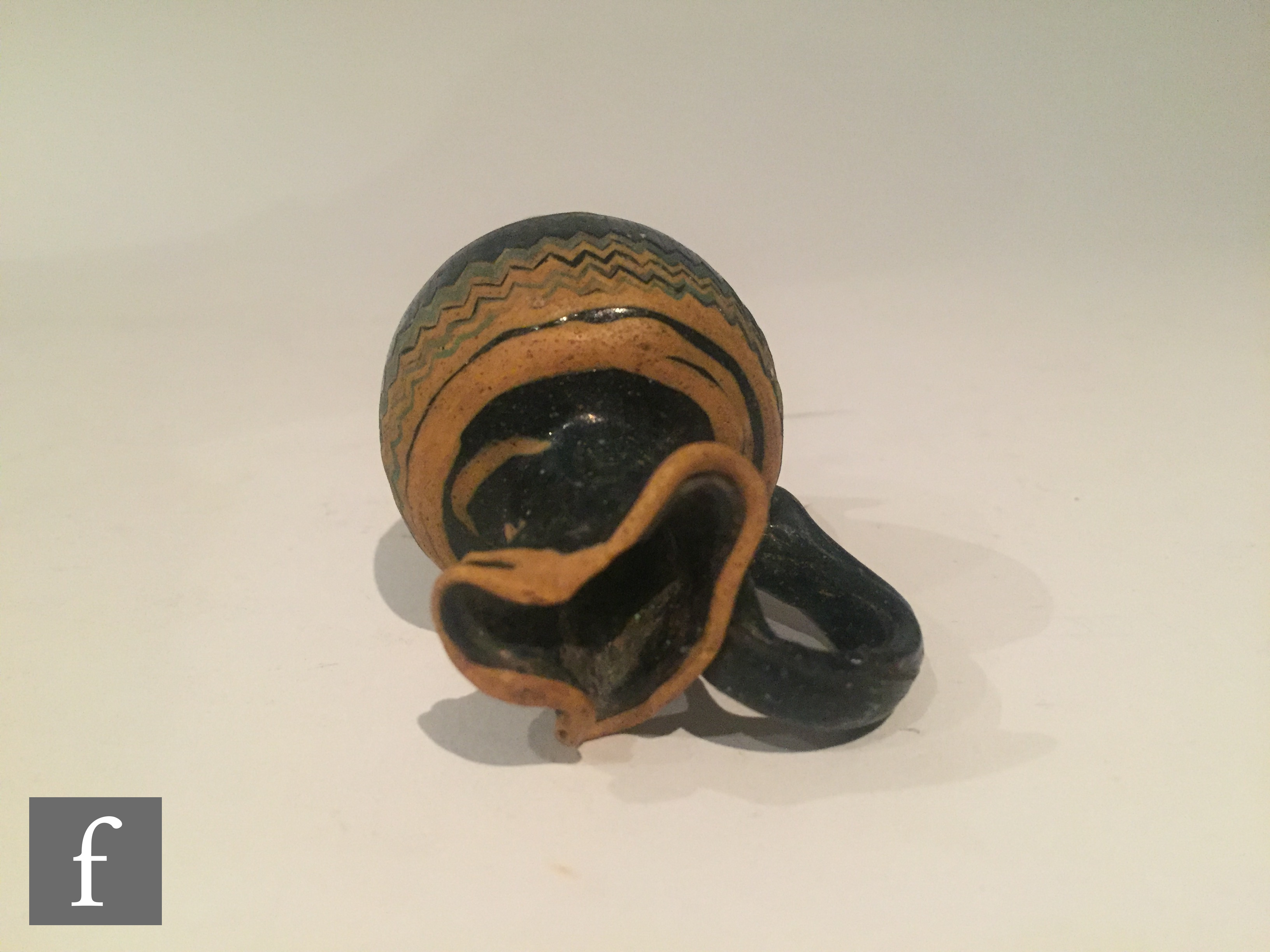 Roman 2nd to 4th Century AD - A miniature dark black glass jug with multi yellow zig zag bands of - Image 6 of 7