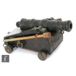 A late 19th to early 20th Century bronze cannon on black painted metal carriage with two mounted
