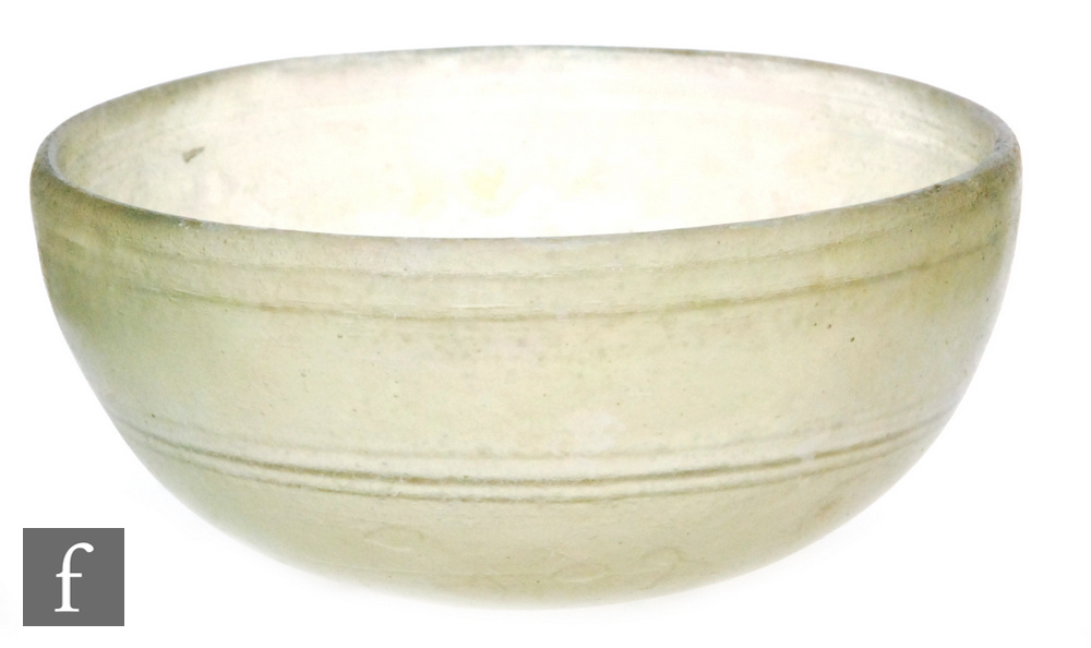 Roman 2nd to 4th Century AD - A pale green glass shallow bowl with traces of iridescence and