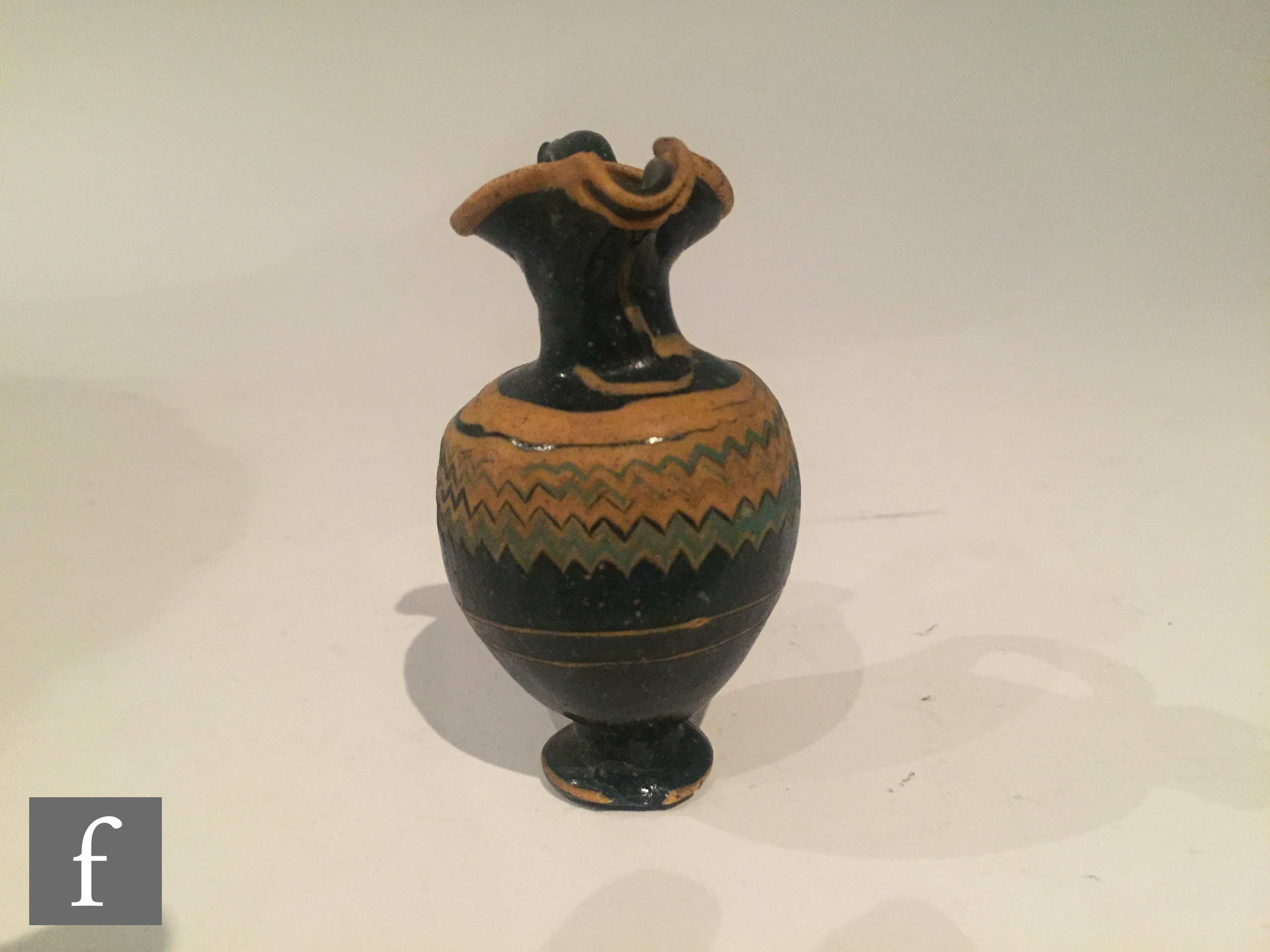 Roman 2nd to 4th Century AD - A miniature dark black glass jug with multi yellow zig zag bands of - Image 5 of 7