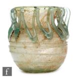 Roman 2nd to 4th Century AD - A pale blue glass bowl with ribbed body and applied lattice