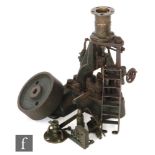 A 1930s cast iron steam engine with vertical oscillating piston, part disassembled,