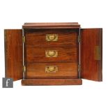 A small Victorian figured walnut three drawer cabinet enclosed by a pair of arch panelled doors,