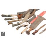 A large Kukri and scabbard and three other Kukris and Malaysian daggers (8)