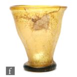 Roman 2nd to 4th Century AD - A small amber glass beaker of tapering form on a circular foot,