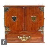 A late 19th to early 20th Century oak smokers cabinet with plated mounts and with twin carry