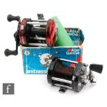 An Abu Ambassadeur 6000 bait casting multiplying reel, black paint finish worn through use,